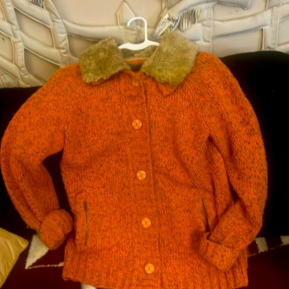 Woman’s orange sweater with detachable fur collar, button up, pockets, with zips